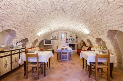 un restaurante con mesas y sillas en una sala de piedra en Agriturismo Masseria Casa Busciana, en Alberobello