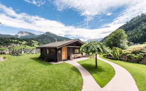 a small cabin in the mountains with a path leading to it at Rainell Dolomites Retreat in Ortisei