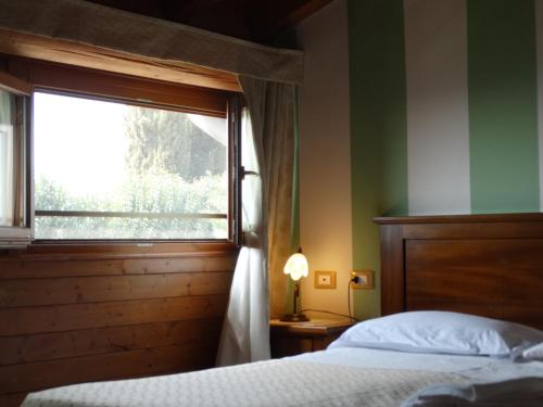 a bedroom with a bed and a window at Agriturismo Casa Rosa in Verona