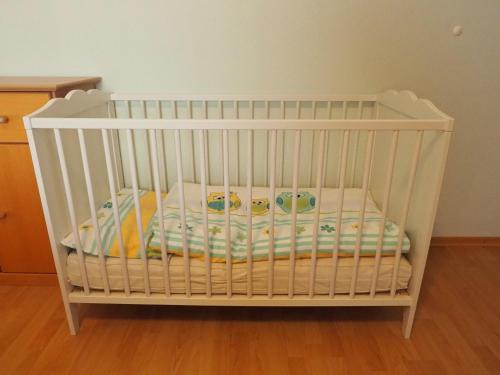 a white crib with some toys in it at Ferienwohnung Herbst in Edelsfeld