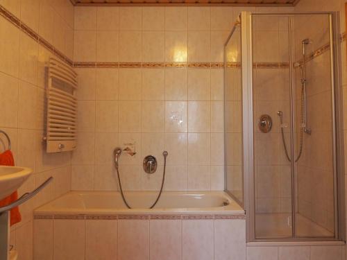 a bathroom with a shower and a bath tub at Ferienwohnung Herbst in Edelsfeld