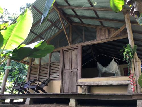 Dos BrazosにあるAmazonita Ecolodgeの窓にハンモックが付いた木造家屋