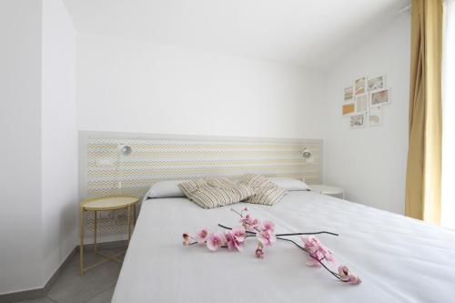 B&B casaMagliana في إيتري: مجموعة من الزهور الزهرية على السرير