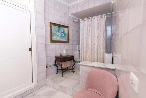 un bagno rosa con sedia rosa e scrivania di Casa en la Corredera Vejer con Terraza y Vistas Privilegiadas a Vejer de la Frontera