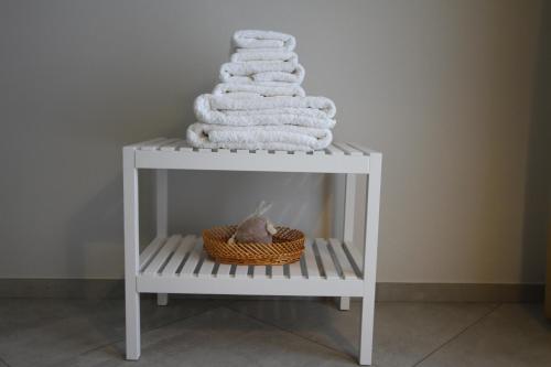 B&B casaMagliana في إيتري: مجموعة من المناشف على طاولة بيضاء مع سلة