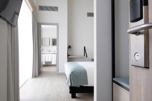 a bedroom with a bed and a view of a bathroom at Martin's Brugge in Bruges