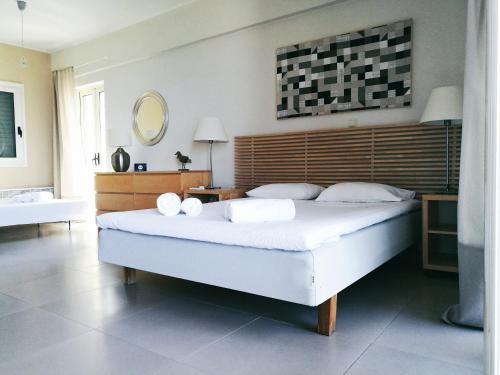 een slaapkamer met een groot wit bed en een spiegel bij Avia Holiday Homes in Avía