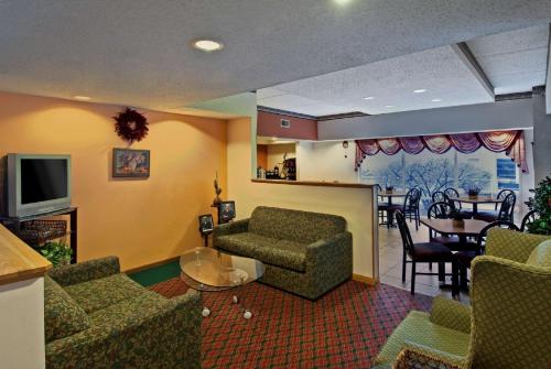 sala de estar con sofá, sillas y TV en Americas Best Value Inn Waukegan, en Waukegan