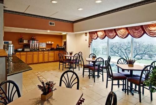 a restaurant with tables and chairs and a large window at Americas Best Value Inn Waukegan in Waukegan
