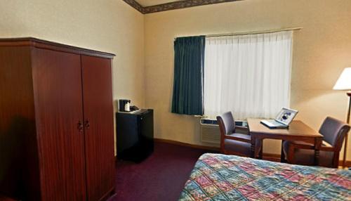 a hotel room with a bedroom with a bed and a desk at Americas Best Value Inn Waukegan in Waukegan
