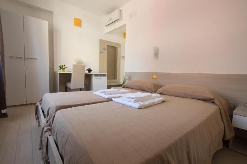 dwa łóżka w pokoju hotelowym z ręcznikami na nich w obiekcie B&B Baglio Santa Croce w mieście Porto Empedocle