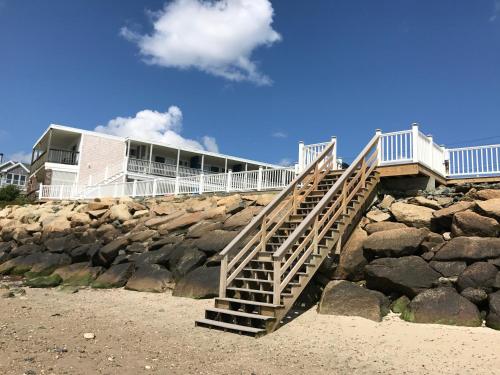 a staircase leading to a house on a rocky beach at The Garlands Motel in Dennis Port