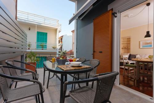 patio con mesa y sillas en el balcón en Metropolis Apartment, en Zakynthos