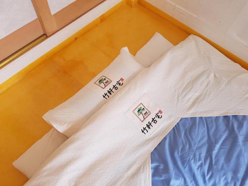 a bed with white pillows on top of it at Jukheon Traditional House in Andong