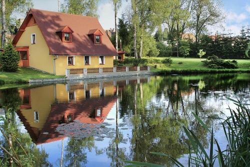 a house is reflected in the water of a lake at Chalupa U rybníčku in Krásná Lípa