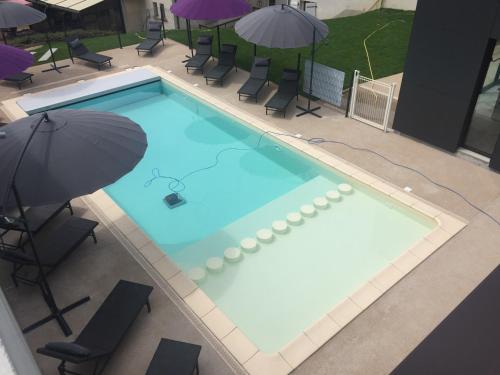 an overhead view of a swimming pool with an umbrella at Logis Hôtel et Spa Chez Camillou in Aumont-Aubrac