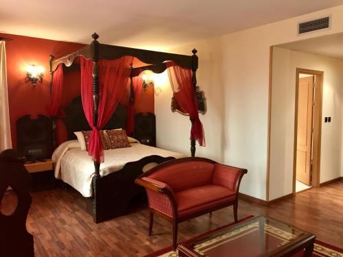a bedroom with a canopy bed and a chair at Hotel Castillo Bonavía in Pedrola