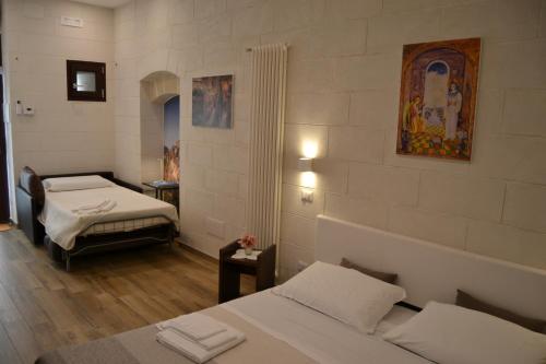 a room with two beds and a painting on the wall at Dimora dell'Annunziata in Matera