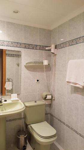 y baño con aseo blanco y lavamanos. en Hotel Cabo de Mar, en Peñíscola