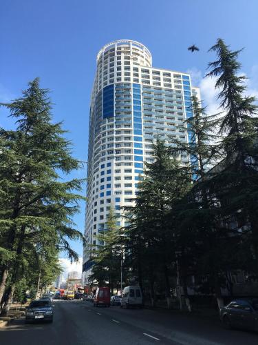 a tall building with cars parked in front of it at Pirosmani Mini Hotel in Batumi