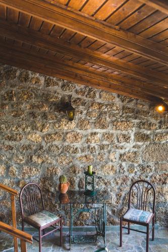 a stone wall with two chairs and a table at Litheon House in Synikia Mesi Trikalon