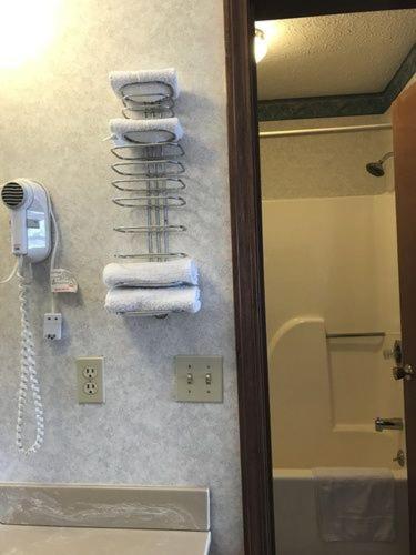 a bathroom with a rack of towels on a wall at Americas Inn Bardstown in Bardstown