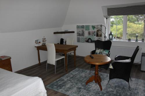 een slaapkamer met een tafel en stoelen en een keuken bij B&B 't Hekkert in Gorssel