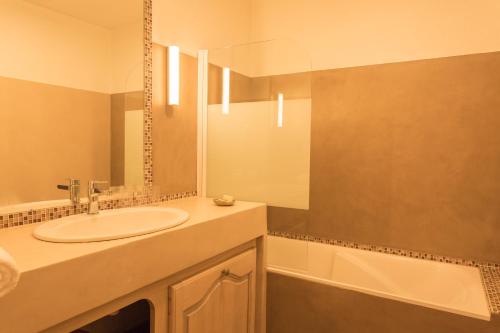 a bathroom with a sink and a tub at Hôtel Le Troubadour à Rocamadour in Rocamadour