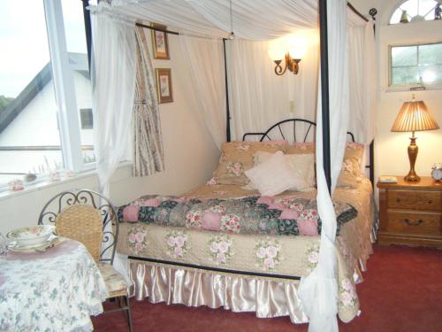 a bedroom with a bed and a table and a window at Murray House in Newport
