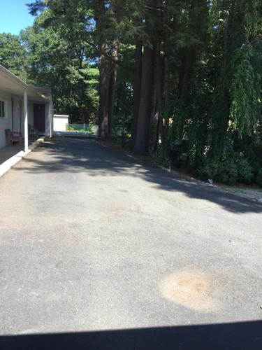 an empty driveway with trees in the background at North King Motel in Northampton