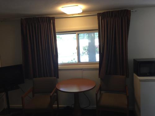 a small room with a table and a window at North King Motel in Northampton