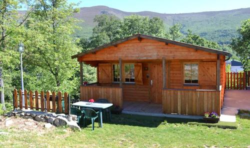 uma cabana de madeira com uma mesa em frente em CABAÑAS LAGO DE SANABRIA em Vigo de Sanabria