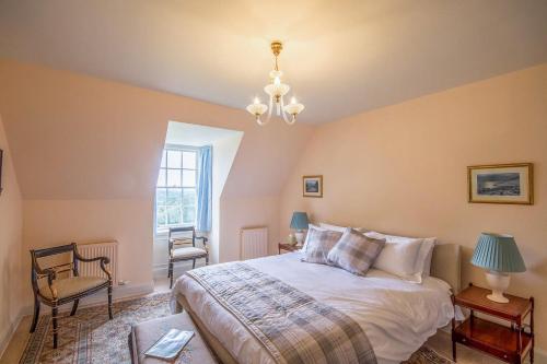 a bedroom with a bed and a chandelier at Blervie House in Forres
