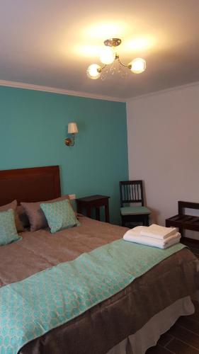 a bedroom with a large bed with blue walls at Che Cauquen in Puerto Santa Cruz