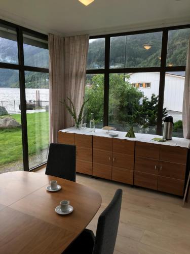 a dining room with a table and a large window at Sogn Hotel in Vadheim