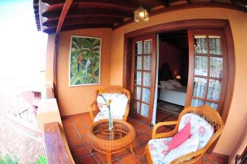 a porch with two wicker chairs and a table at Hotel Emblemático San Marcos in Icod de los Vinos