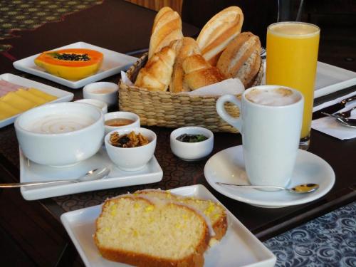 een tafel met borden brood en kopjes koffie bij Pousada Castelo Do Vento in Prea