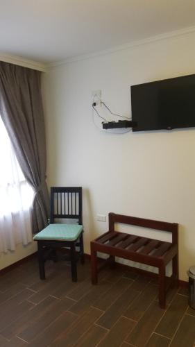 a room with two chairs and a flat screen tv at Che Cauquen in Puerto Santa Cruz