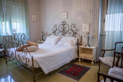 a bedroom with a large white bed and two chairs at Un tuffo nella baia di Capomulini in Acireale