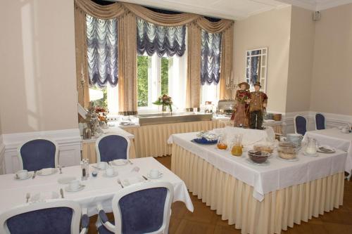 a dining room with two tables and blue chairs at Schloss Hotel Wolfsbrunnen in Schwebda