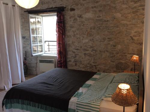 une chambre avec un lit et un mur de briques dans l'établissement Maison Ancienne Minervois, à La Caunette