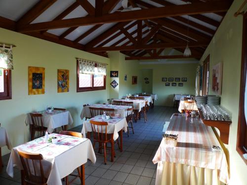 a restaurant with tables and chairs with white tablecloths at Pousada Barratur in Florianópolis