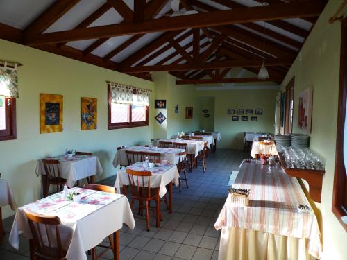 un restaurante con mesas y sillas con manteles blancos en Pousada Barratur, en Florianópolis