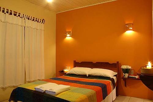 1 dormitorio con 1 cama con 2 toallas en Pousada Barratur, en Florianópolis