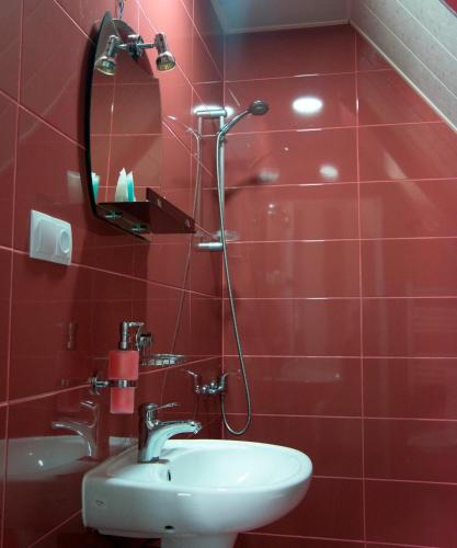 a red bathroom with a sink and a mirror at OISHE Boutique Hotel in Stepantsminda