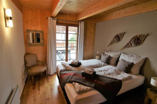 a bedroom with a bed and a chair and a window at Mountain Village Chalet in Saas-Fee