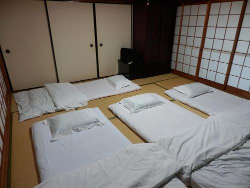 a group of four beds in a room at Setonejuan in Takamatsu