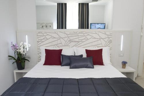 ein Schlafzimmer mit einem großen Bett mit roten und grauen Kissen in der Unterkunft Merulana Holidays in Rom