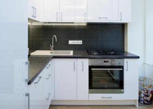 a white kitchen with a sink and a stove at Town Hall Square Apartments in Vilnius