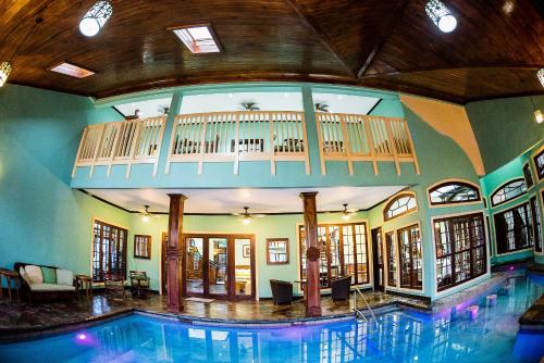 a swimming pool in a house with a balcony at Villa Dora Mae in Ocho Rios